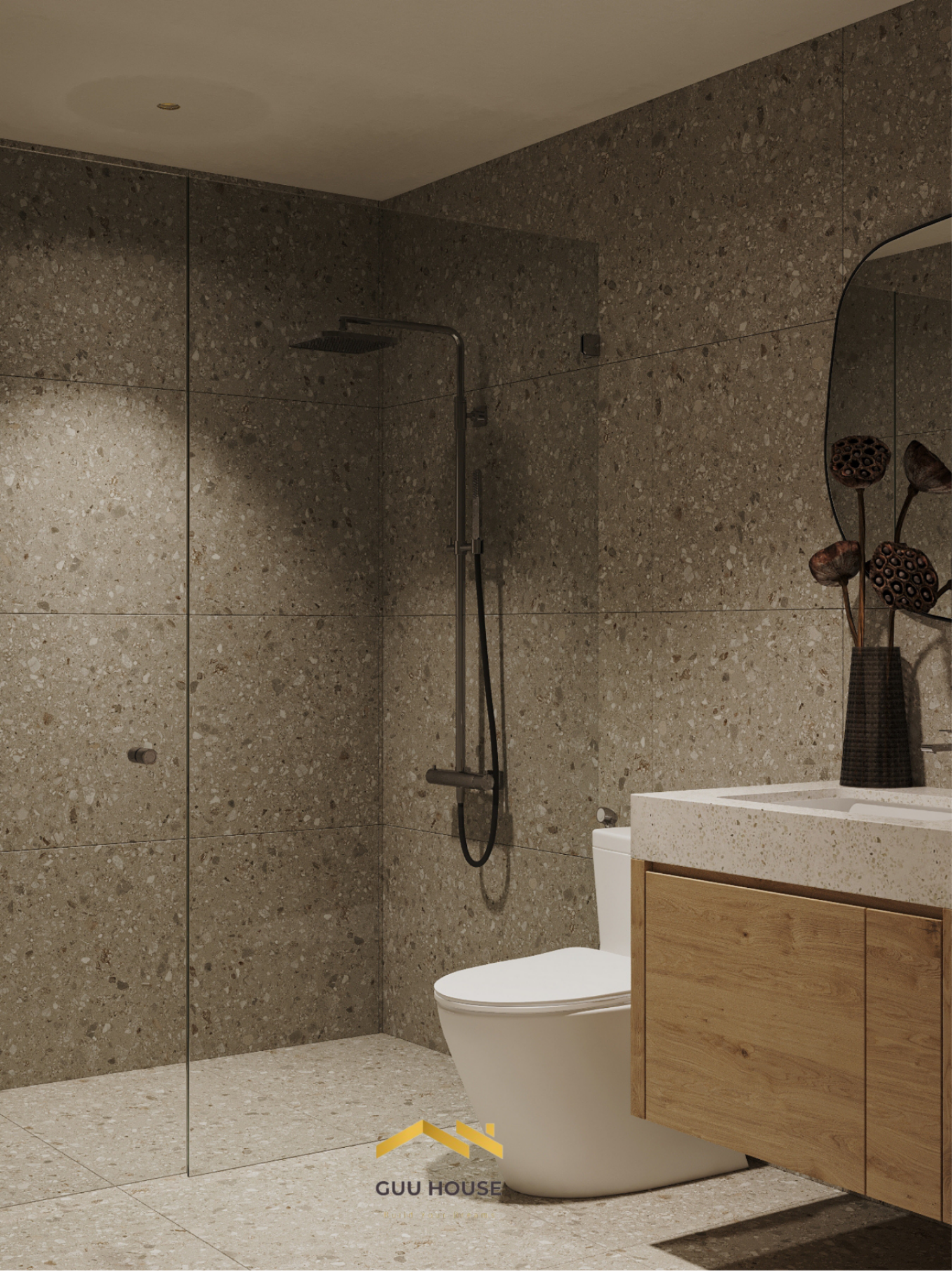 Khu vực tắm đứng kính trong với tường đá terrazzo màu nâu xám, thiết bị vệ sinh hiện đại ánh sáng ấm