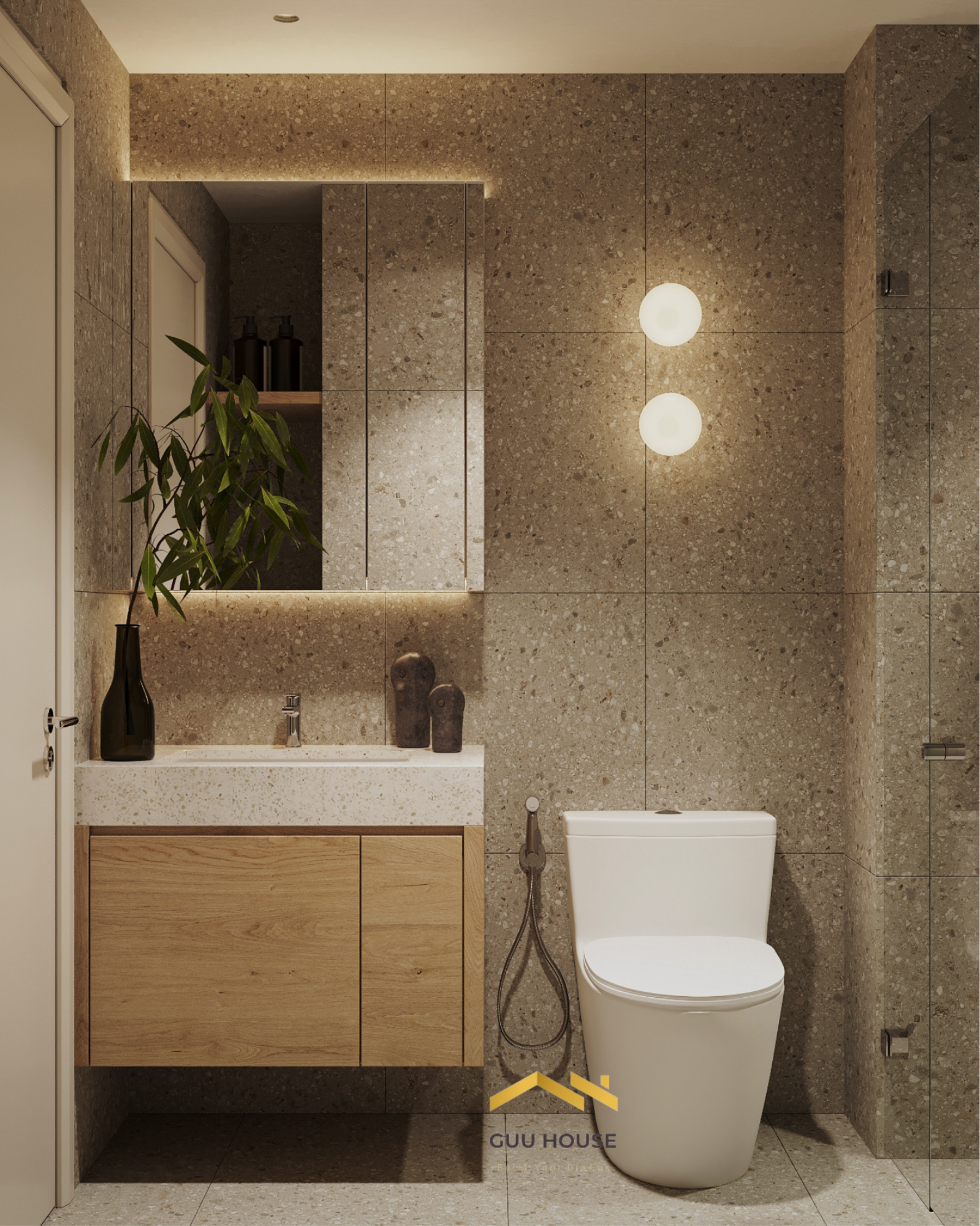 Phòng tắm tông be nâu với tường đá terrazzo, lavabo treo và tủ gỗ tối giản hiện đại